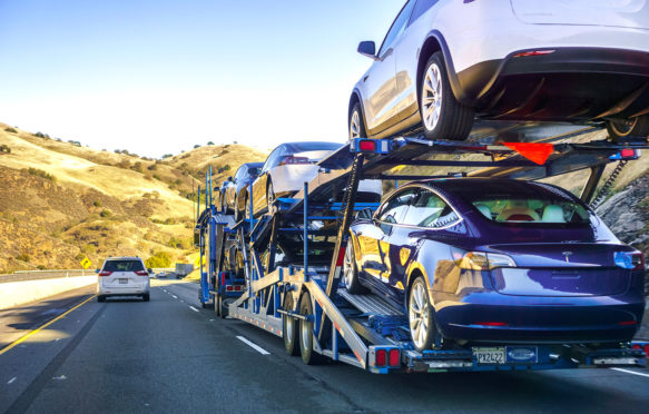 汽车运输新3特斯拉模型汽车沿着公路,加州,美国。信贷:安德烈•除股票的照片。R6HR26