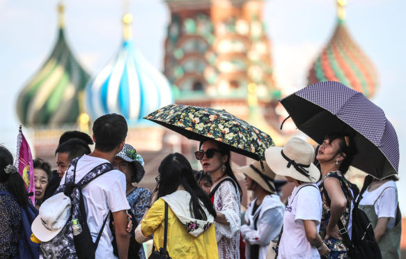 人撑一把伞在热浪在莫斯科,2018年8月3日。信贷:塔斯社除股票的照片。
