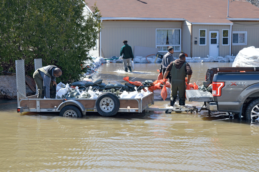 志愿者帮助移动沙袋来保护一个家庭从渥太华加拿大附近的洪水上涨,在2019年洪水