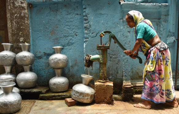 女人收集水从井在热浪在达卡,孟加拉国,2019年5月20日。来源:新华社除股票的照片。