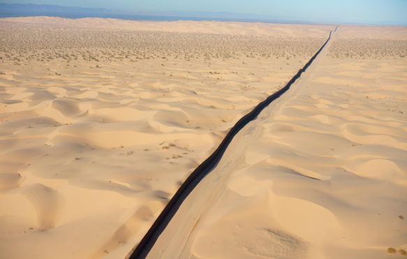 国际边界:墨西哥-美国(鸟瞰图)。此在索诺兰沙漠沙丘,墨西哥下加利福尼亚墙(左)