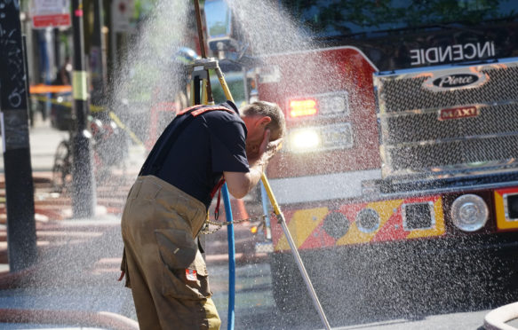 消防员冷却后与火在炎热的天气里在蒙特利尔,加拿大2021年6月