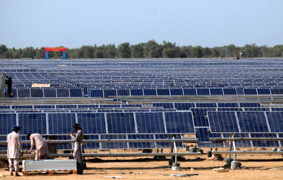 在巴基斯坦工人安装太阳能光伏板。