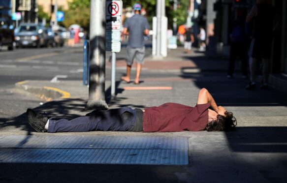 一个男人躺在人行道上热浪在波特兰,俄勒冈州,U。年代,2021年8月11日。