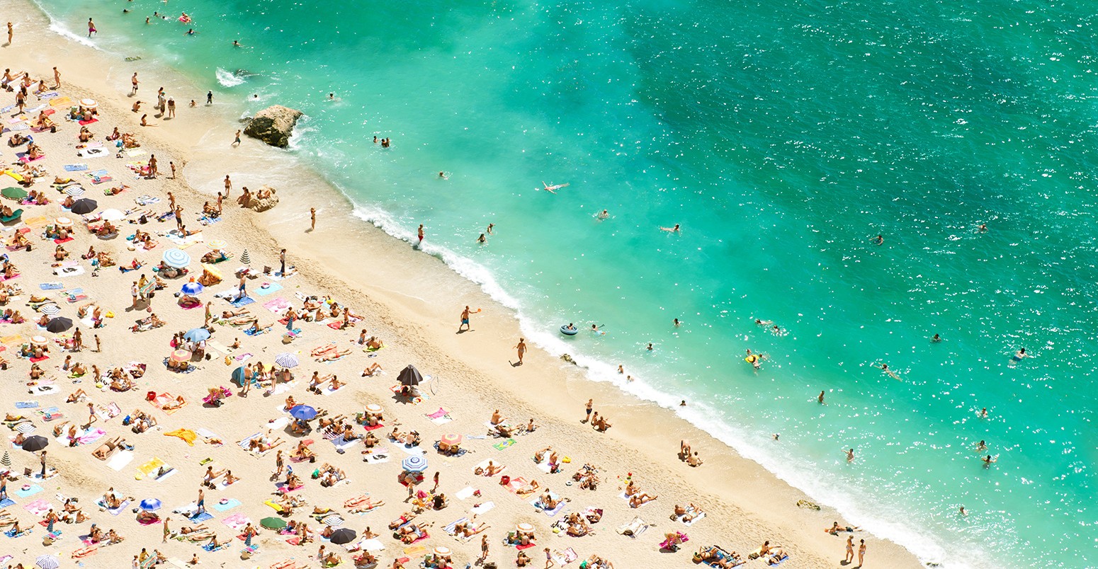 Cote d'azur的海滩与游人，日光浴浴床和伞在炎热的夏日