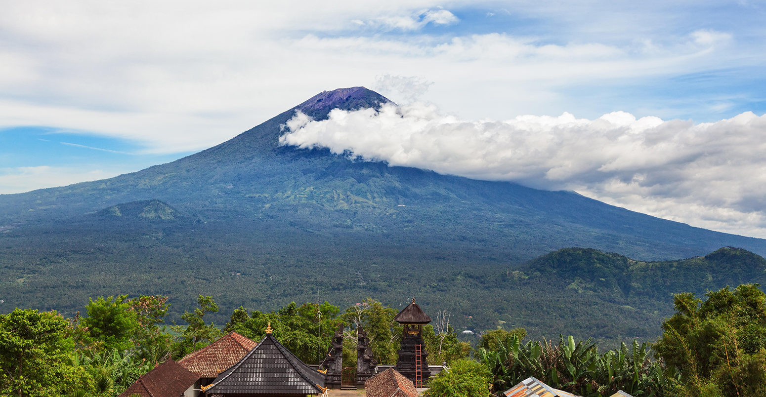 从伦浦阳山到传统的巴厘寺庙在阿贡山斜坡背景。阿贡火山是巴厘岛最高的活火山。