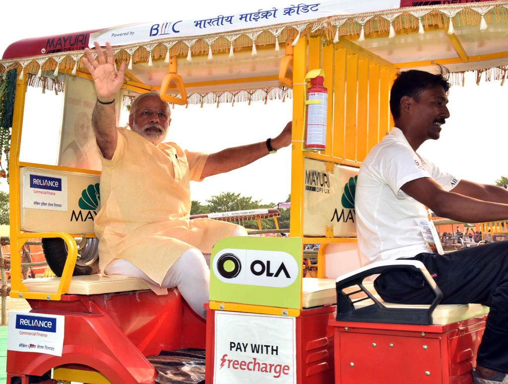 印度总理纳伦德拉•莫迪骑全电动机动黄包车发放1000后车辆的选民。印度瓦拉纳西,5月1日,2016年。G0K24P