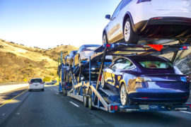 汽车运输车沿着高速公路携带新的Tesla型号3辆车。信用：安德烈斯坦斯科/ alamy股票照片。R6HR26.