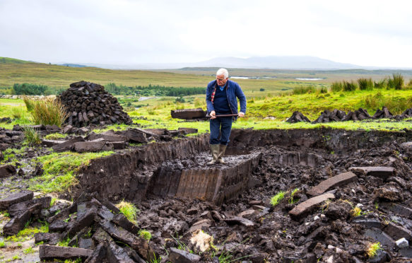 在爱尔兰共和国的康尼马拉国家公园，一块块泥炭正在被切割。来源:robertharding / Alamy Stock Photo。
