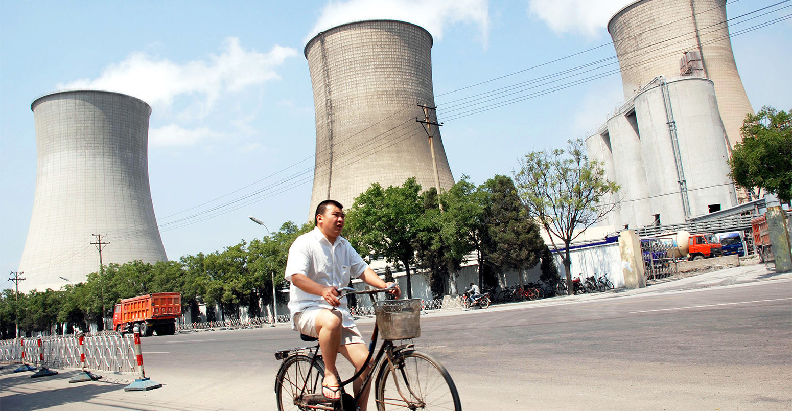 一名骑自行车的人经过中国北京的一家燃煤电厂。资料来源:想象中国有限公司/ Alamy Stock Photo。W9CEBT