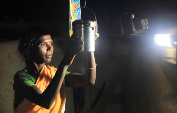LED灯泡照亮了一个女人，就像她在印度卡纳塔克邦的晚上做家务一样。图片来源：Zuma Press，Inc。 / Alamy Stock Photo。d9rydr