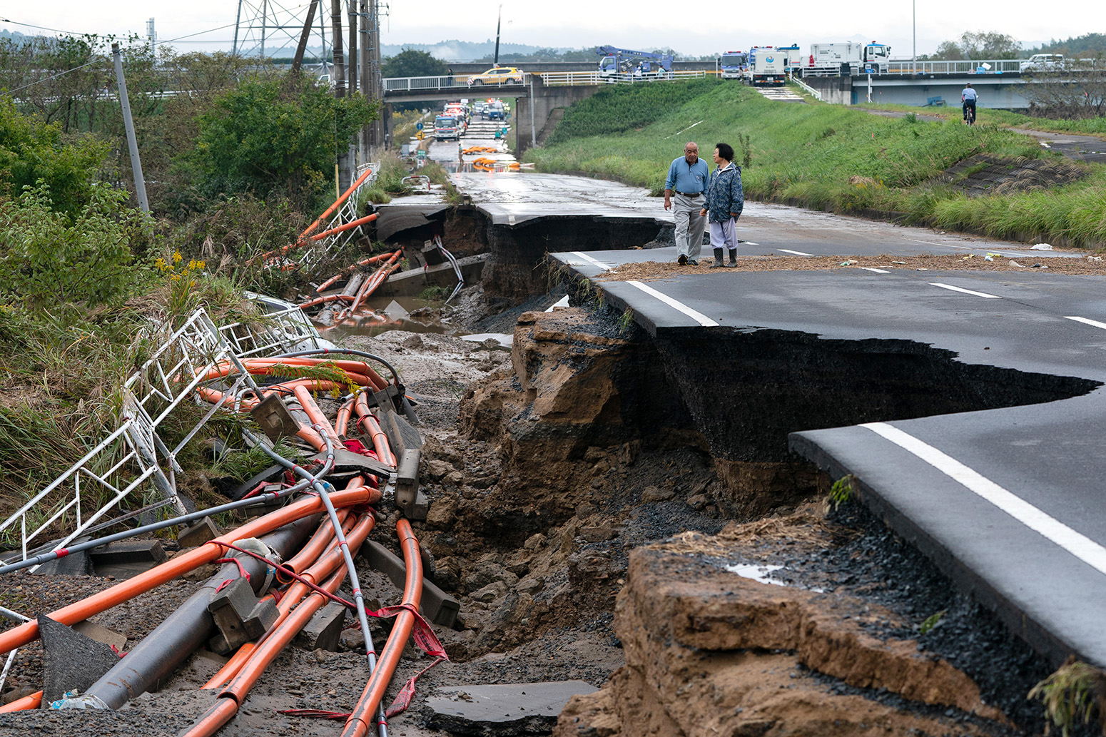 当地居民在日本米达市哈吉毕基比斯之后走在一个倒塌的道路上。2019年10月15日。学分：SOPA图象有限/ Alamy股票照片。2a4tf31.