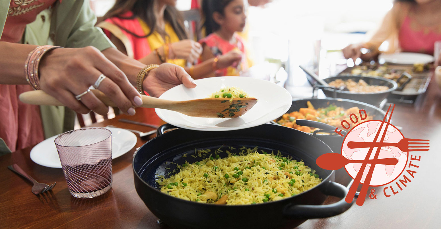 穿着莎丽服的印度妇女在餐桌上服务和吃食物。图片来源:Barry Diomede / Alamy Stock Photo。