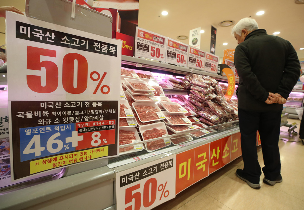 一个人浏览美国牛肉在架子上打折商店在首尔,韩国。