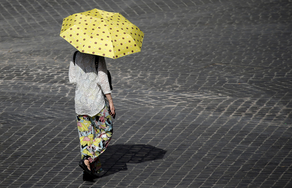 热浪袭击意大利，一名妇女在罗马市中心躲避阳光。