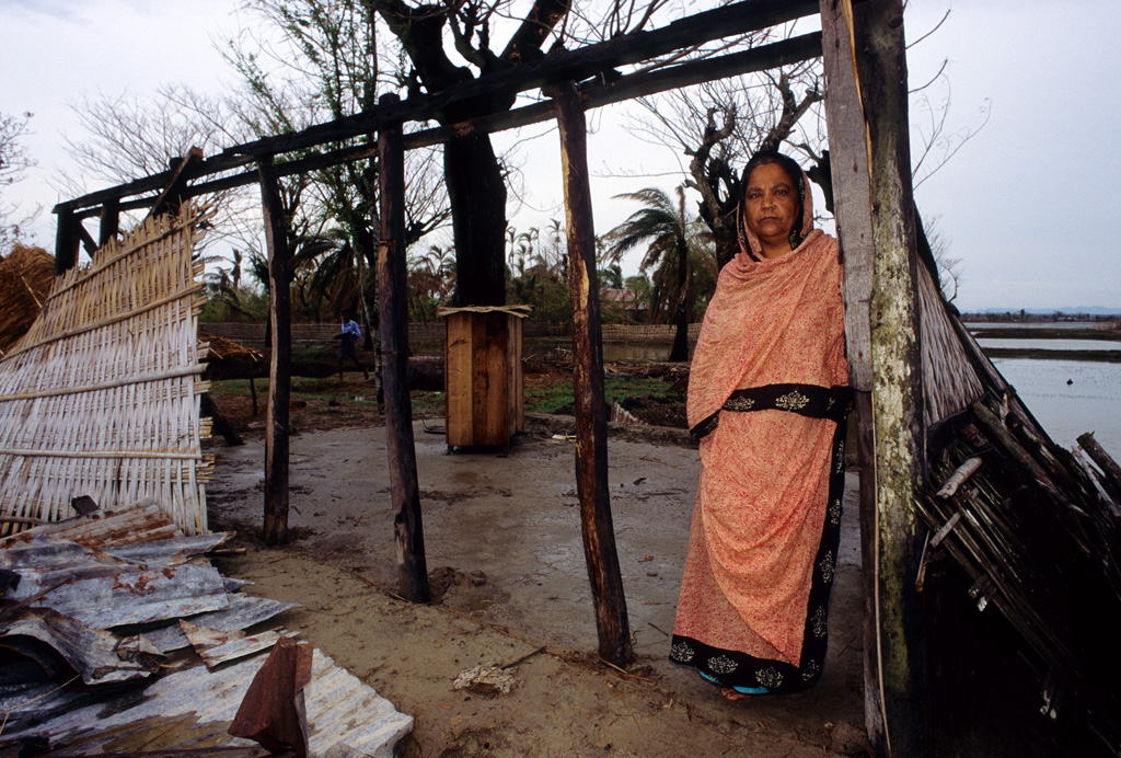 A-woman-stands-at-the-wreckage-of-her-home, -in-Banshkhali-Bangladesh