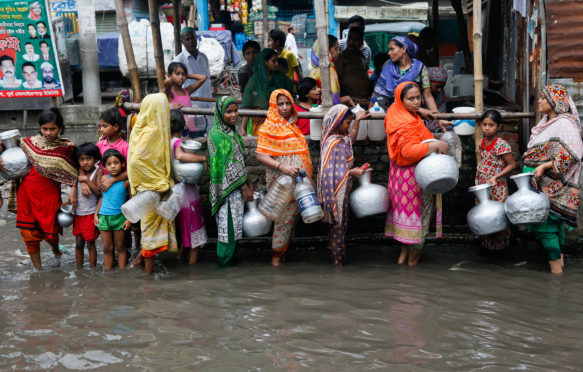 妇女和儿童从水记录收集饮用水地区在达卡,孟加拉国,2017年6月。信贷:Mehedi哈桑除股票的照片。