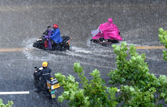 人骑在暴雨后的道路在郑州