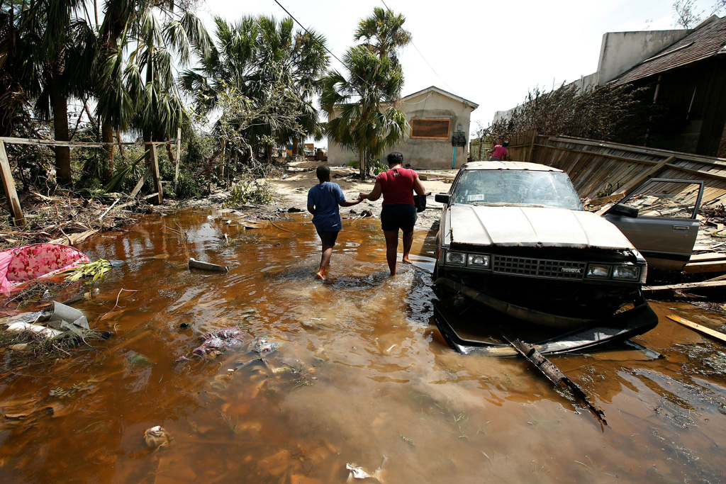 一个女人和一个孩子走进在巴哈马群岛马修飓风过后他们淹没了房子