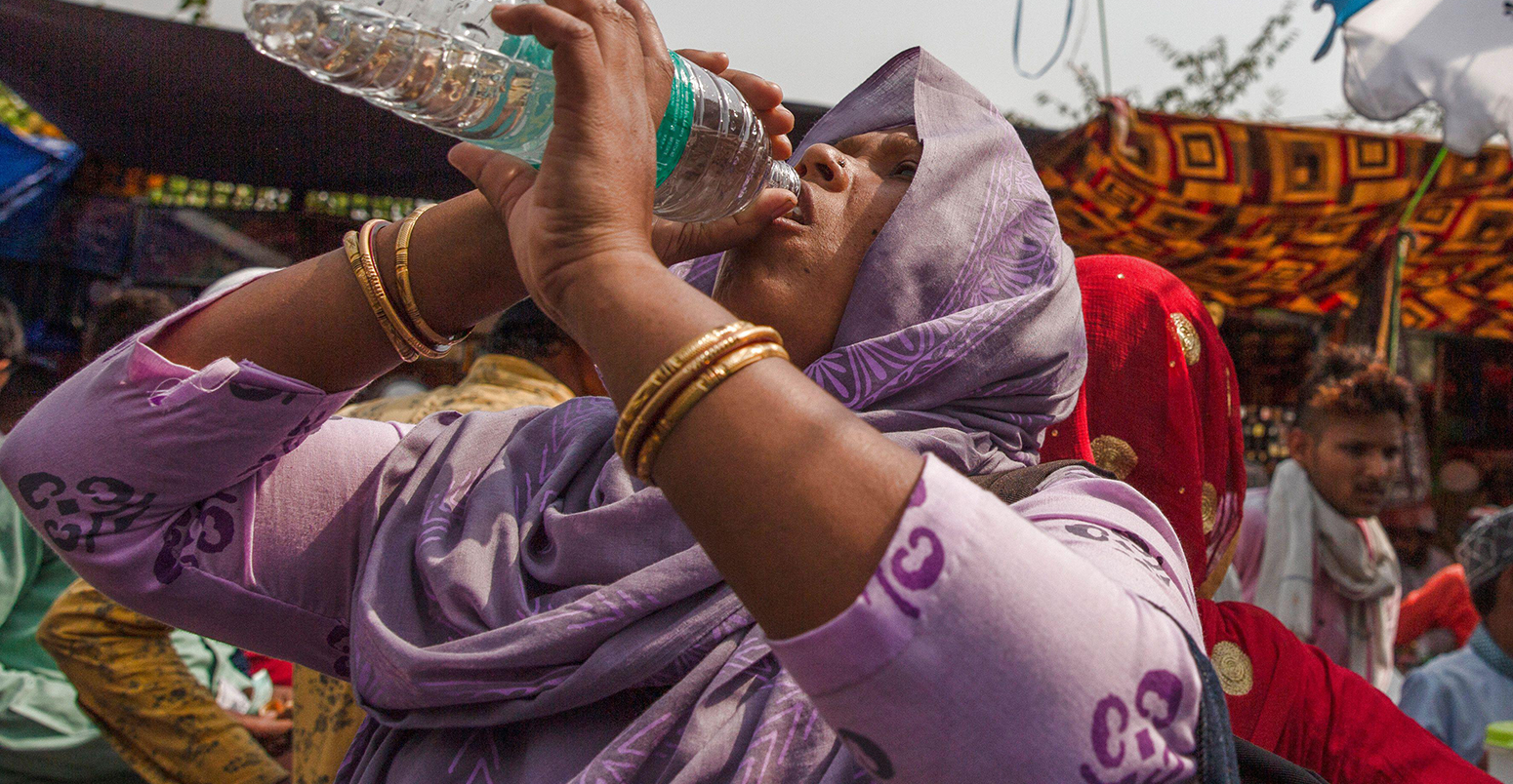 一个女人喝水在新德里在炎热的一天,2022年4月29日