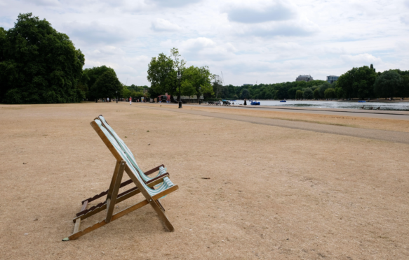 2022年7月，在热浪期间，英国伦敦海德公园的焦草和空甲板椅子。图片来源：Matthew Chattle / Alamy Stock Photo。