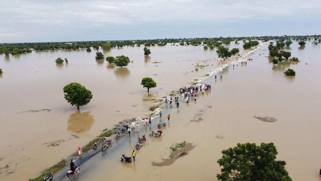 人们走过洪水在Hadeja暴雨之后,尼日利亚,2022年9月19日。