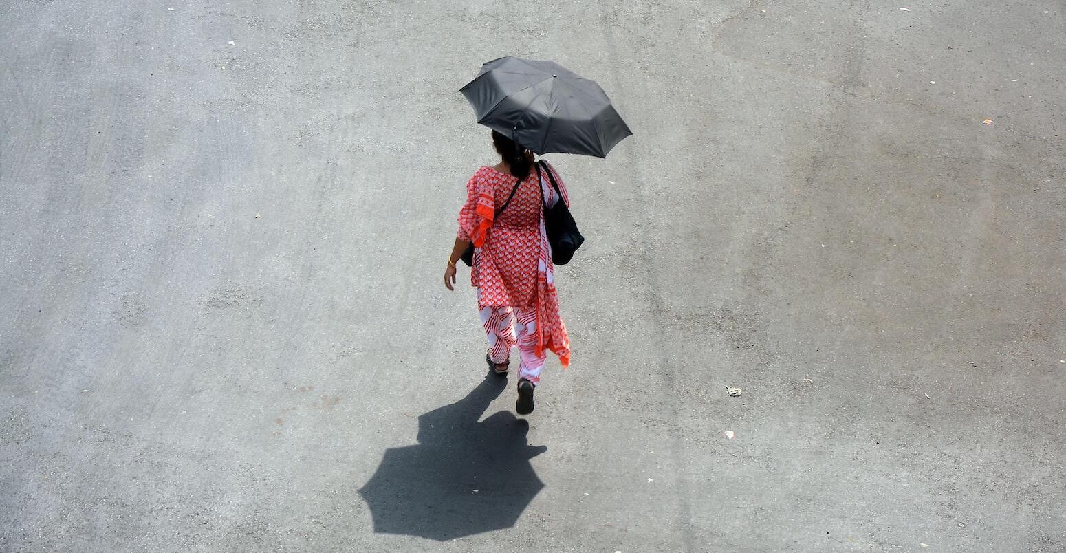 外一个女人拿着一把伞在炎热的夏天在加尔各答,印度4月26日,2022年。