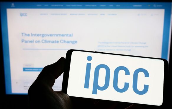 人持有智能手机标志的政府间气候变化专门委员会(IPCC)在屏幕上的网站。专注于手机显示。