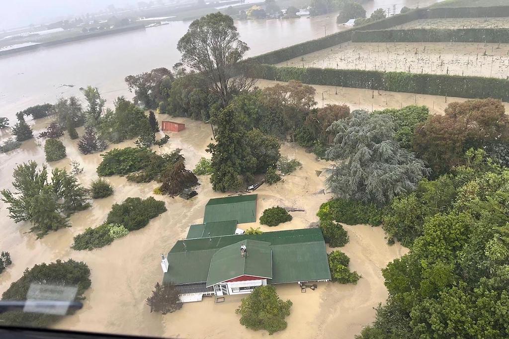 人站在屋顶上等待被直升机吊安全加布里埃尔强热带风暴造成的洪水期间,面谷,新西兰,2023年2月15日。