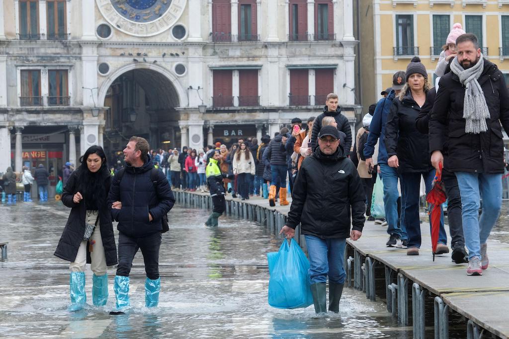 人们通过水淹韦德在威尼斯圣马可广场季节性高水位期间,意大利,2022年12月10日。