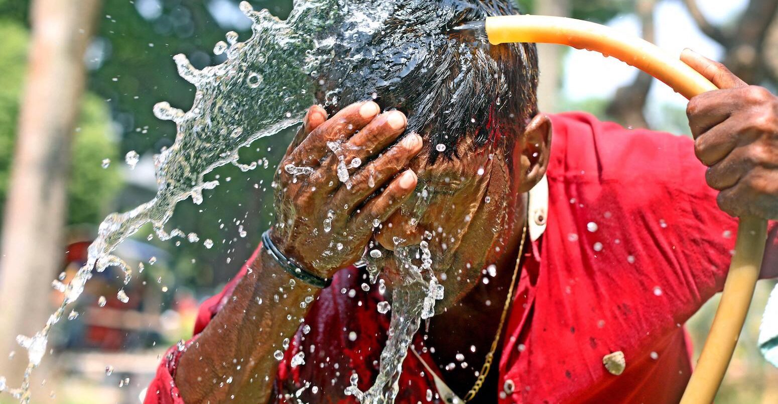 一个人洗他的脸与水在高温天气天在达卡,孟加拉国,2023年4月11日。